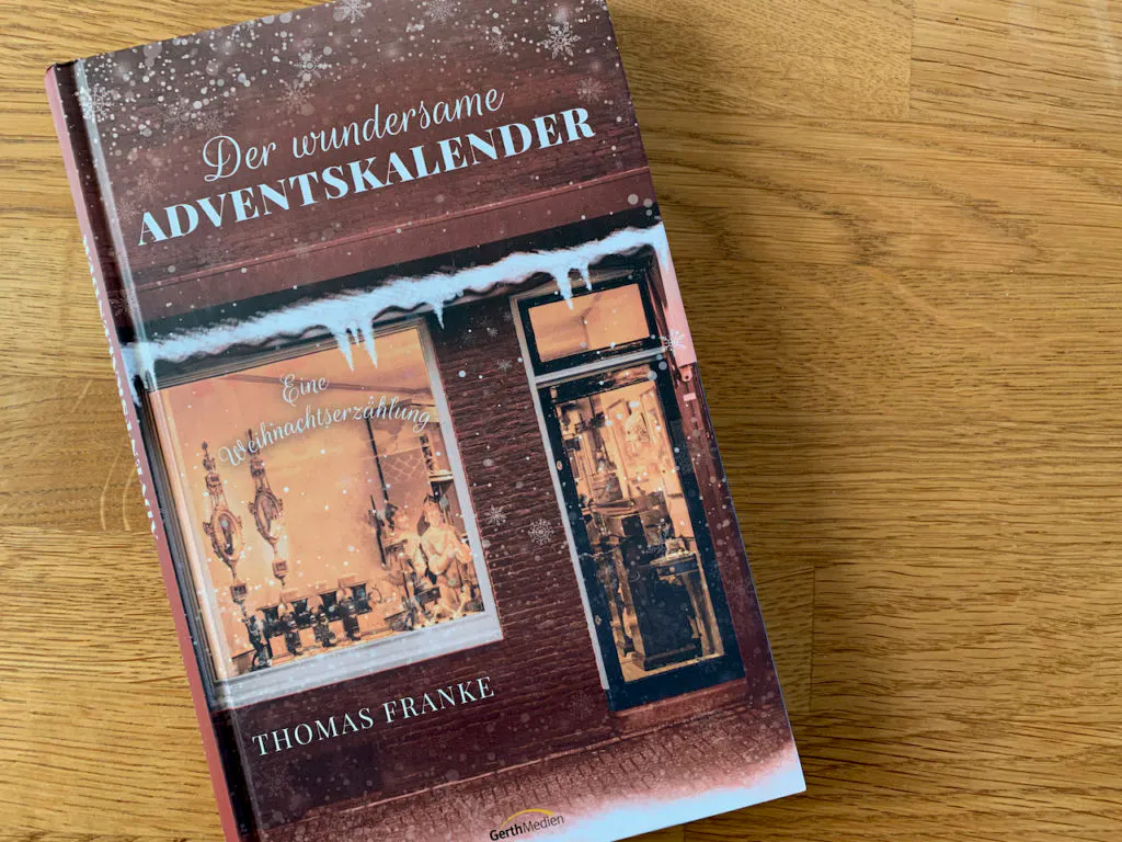 Buch "Der wundersame Adventskalender" auf einem Holztisch