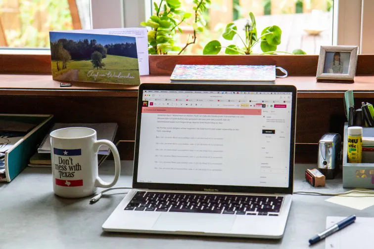 Schreibtisch mit Laptop und Tasse