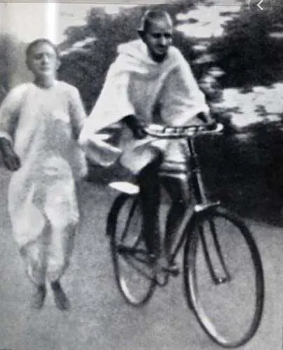 Mahatma Gandhi auf einem Fahrrad.