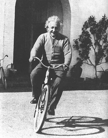 Albert Einstein fährt auf einem Fahrrad. Schwarz-weiß Foto.