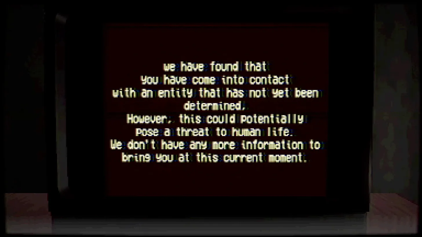 Ein Röhrenfernseher mit schwarzem Hintergrund auf einem Holztisch. Darauf in weiß der Text: "We have found that you have come into contact with an entitiy that has not yet been determined. However, this could potentially pose a threat to human life. We don't have any more information to bring you at this current moment."