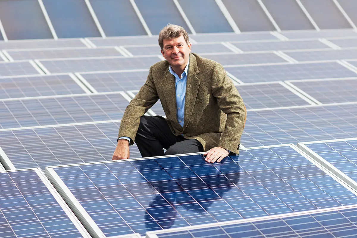 Olaf Höhn zwischen Solarmodulen auf dem Dach der Florida Eis Manufaktur
