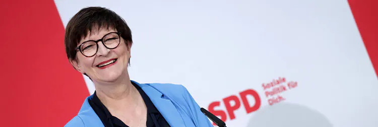 Saskia Esken lächelt. Im Hintergrund ist ein SPD-Logo.